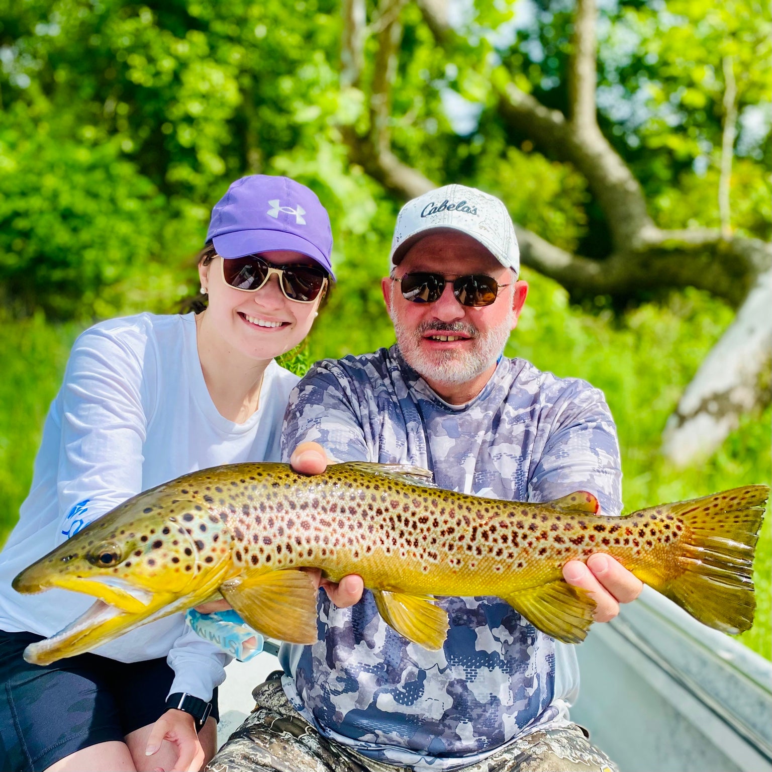 Two anglers with a brown trout after a guided trip